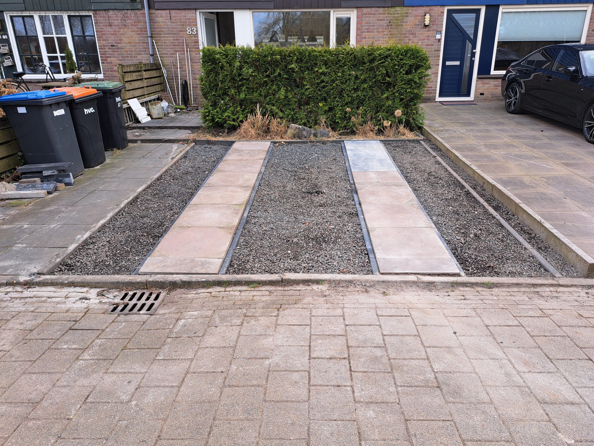 Oprit met tegelstroken en split, door ons aangelegd in Lelystad